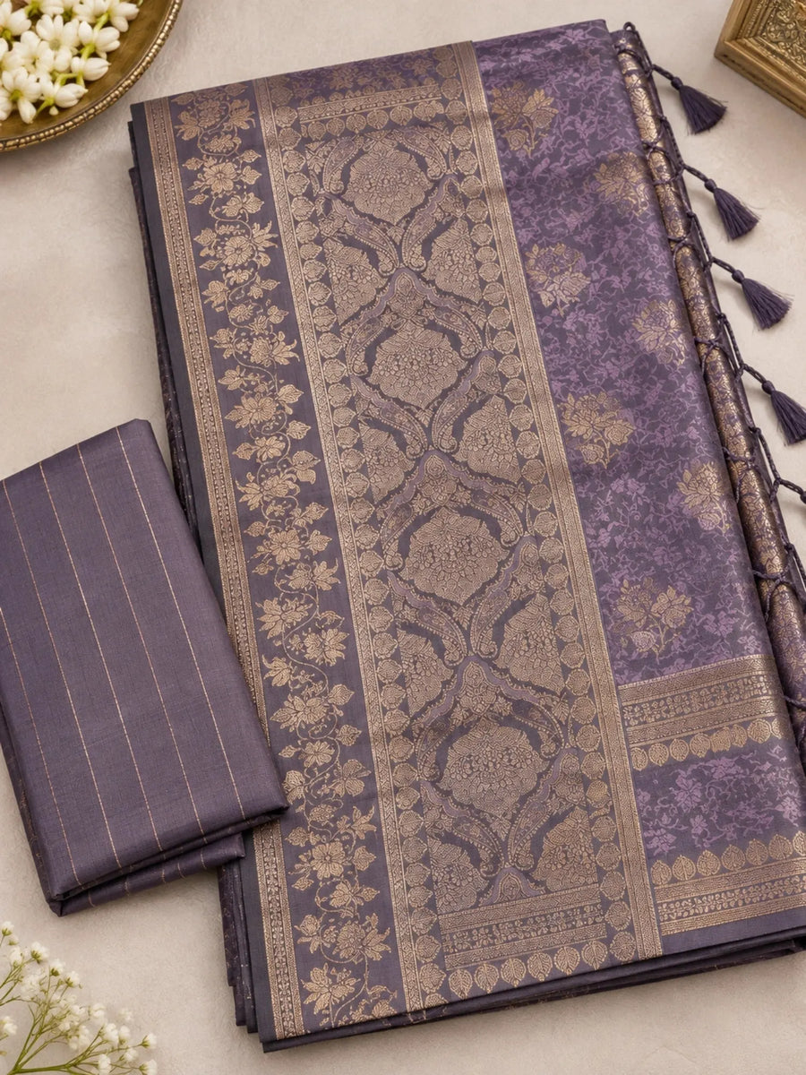 woman wearing a lavender purple silk saree featuring intricate floral motifs, a richly detailed traditional zari border