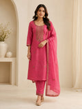 Woman wearing a pink embroidered suit with matching pants and a sheer dupatta indoors.
