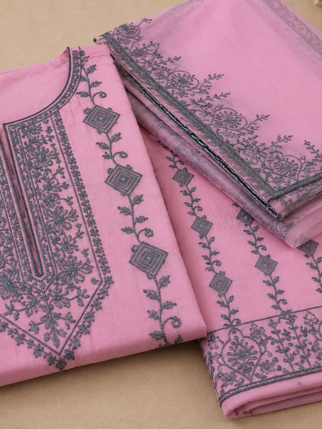 Woman wearing a pink suit with grey floral embroidery, matching pants and a flowing dupatta.