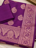 Purple silk saree with gold floral motifs and an ornate woven border on a woman.