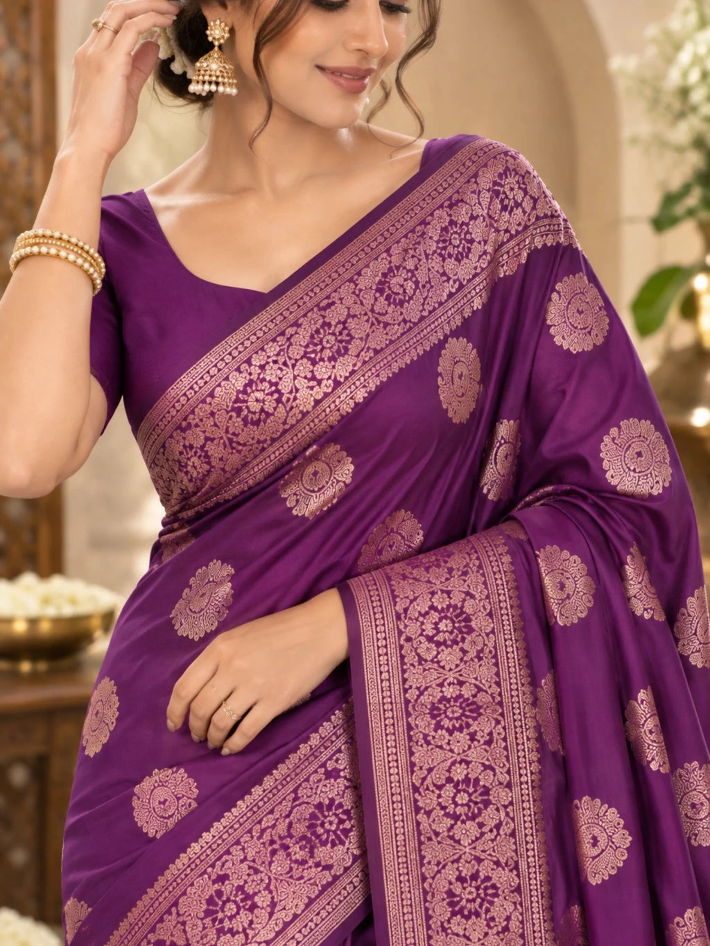 Purple silk saree with gold floral motifs and an ornate woven border on a woman.