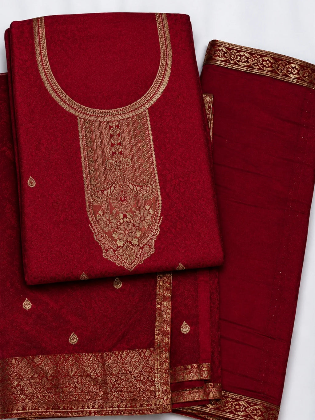 Woman wearing a deep red suit with gold embroidery, matching pants and an ornate dupatta.