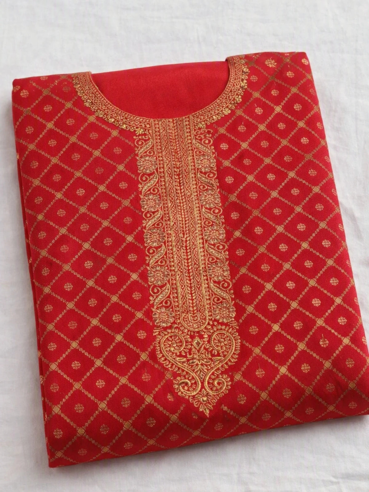 Woman wearing a red embroidered suit with matching pants and a multicolored printed dupatta.