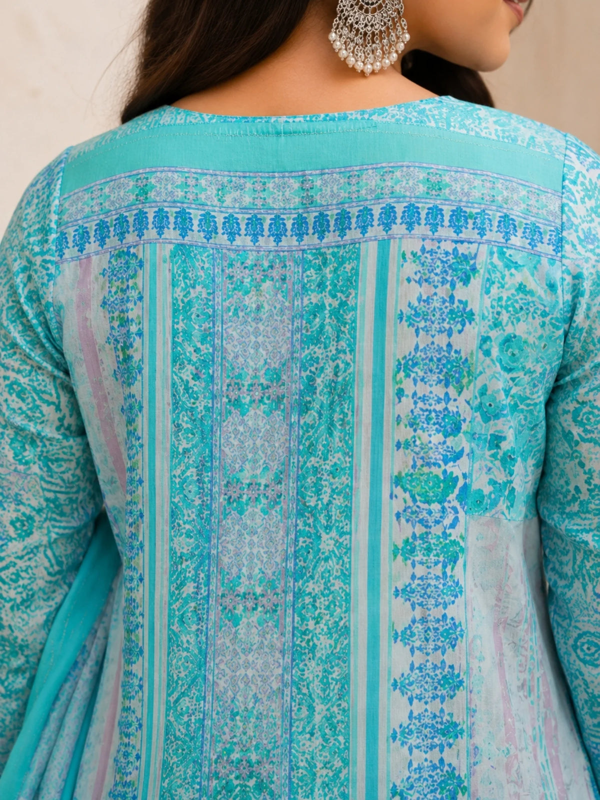 Woman wearing a turquoise printed kurta palazzo set with a matching flowing dupatta.