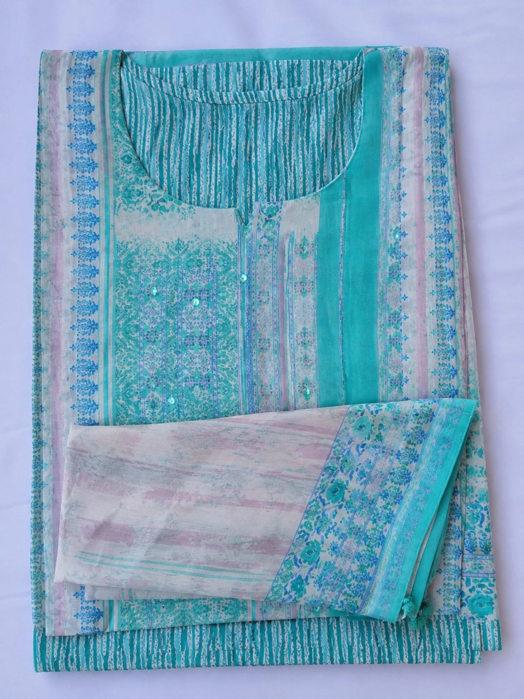 Woman wearing a turquoise printed kurta palazzo set with a matching flowing dupatta.
