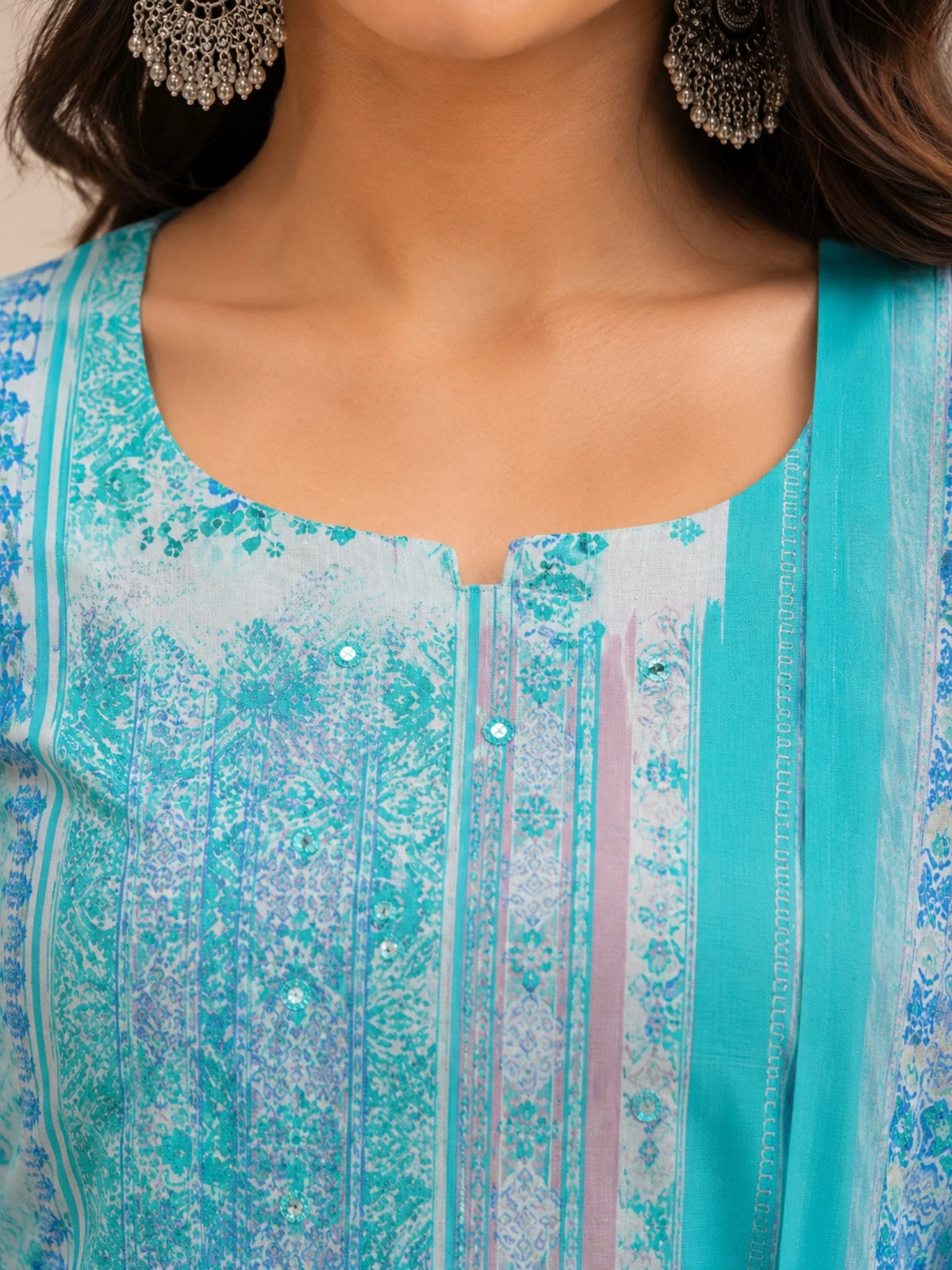 Woman wearing a turquoise printed kurta palazzo set with a matching flowing dupatta.