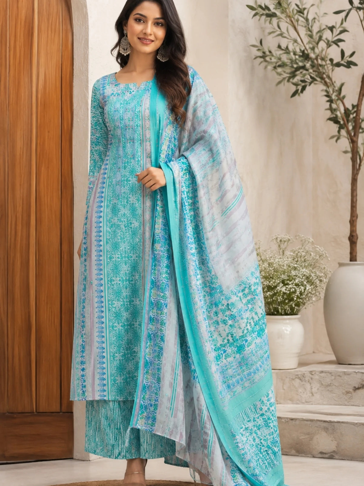Woman wearing a turquoise printed kurta palazzo set with a matching flowing dupatta.